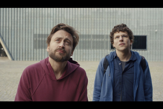 Scène du film A Real Pain : les deux cousins , David et Benji, face au monument de l'Insurrection, à Varsovie.